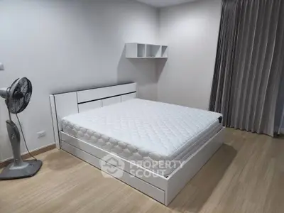 Modern minimalist bedroom with sleek white furniture and wooden flooring