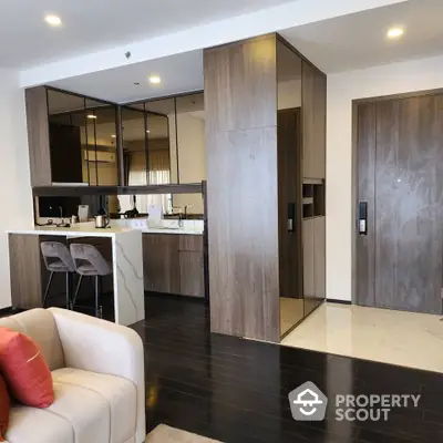 Modern open-layout kitchen with sleek cabinetry and stylish bar stools in a contemporary apartment.