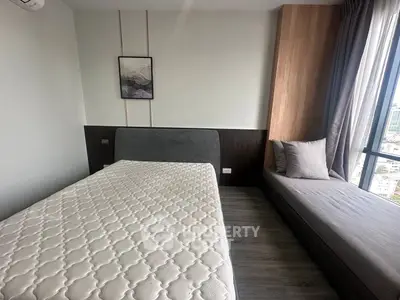 Modern bedroom with stylish decor and large window offering city views