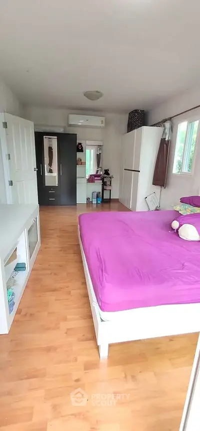 Spacious bedroom with vibrant decor and ample natural light