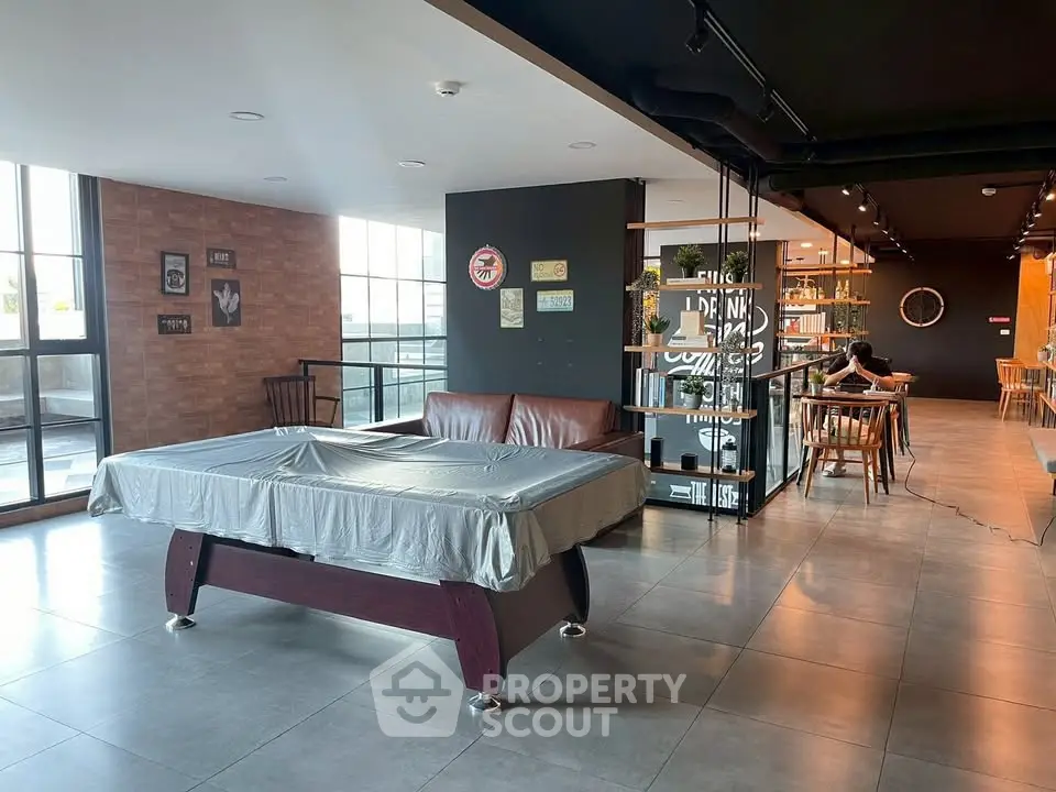 Spacious modern common area with pool table and seating, ideal for social gatherings.