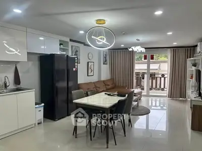 Modern open-layout kitchen and living room with stylish decor and ample natural light.