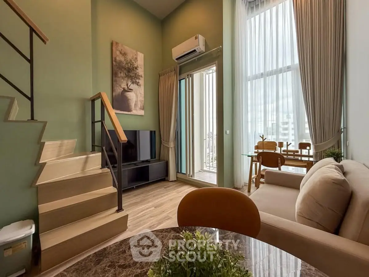 Modern duplex living room with high ceilings and large windows, featuring elegant decor and a cozy atmosphere.