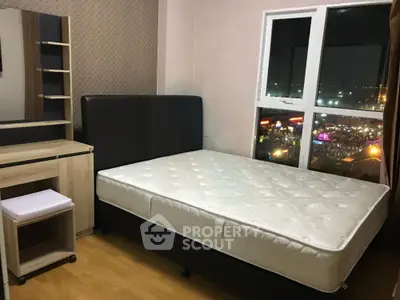 Cozy bedroom with city view, featuring a comfortable bed and stylish wooden furniture.