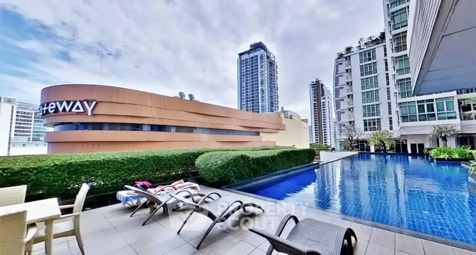 Luxurious rooftop pool with city skyline views and modern lounge chairs.