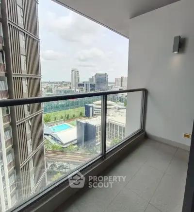 Spacious balcony with stunning cityscape view in modern high-rise apartment.