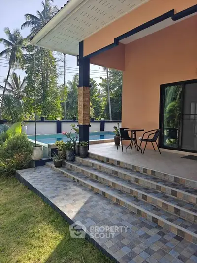 Charming tropical home with poolside patio and lush garden, perfect for relaxation and outdoor enjoyment.