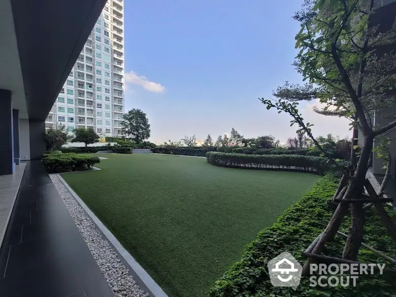 Luxurious garden area with lush greenery and modern high-rise building view