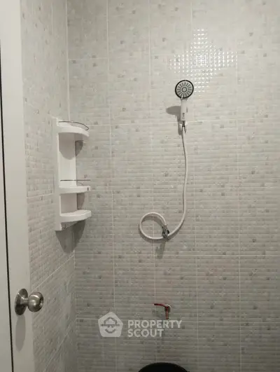 Compact bathroom with tiled walls and modern shower fixture, ideal for efficient space use.
