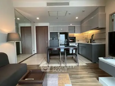 Modern open-plan living room and kitchen with sleek design and ample natural light.