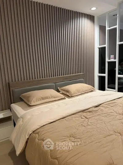 Modern bedroom with stylish wood paneling and cozy bedding