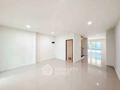 Spacious empty living room with glossy floors and natural light