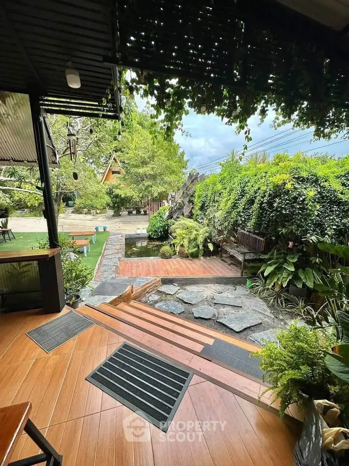 Charming garden view with lush greenery and serene pond, perfect for relaxation and outdoor enjoyment.