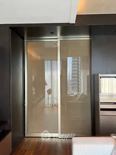 Luxurious modern living room with floor-to-ceiling windows and sleek wooden flooring.