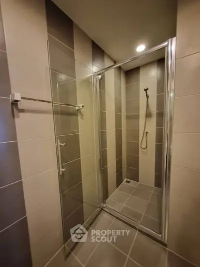 Modern bathroom with glass shower enclosure and sleek tile design.