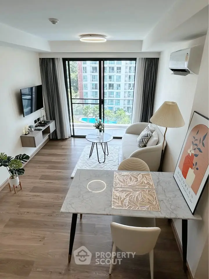 Modern living room with stylish decor and large windows offering a stunning view of the cityscape.