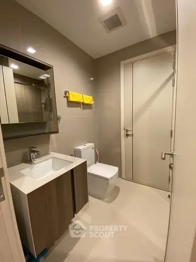 Modern bathroom with sleek fixtures and neutral tones, featuring a stylish vanity and contemporary design.