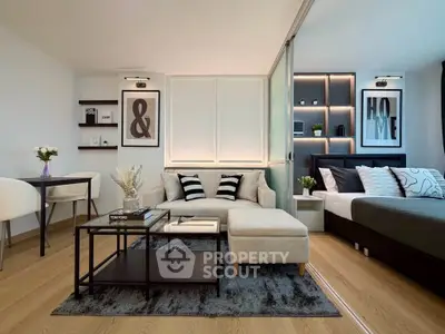Modern studio apartment with stylish decor, featuring a cozy living area and a comfortable bed.
