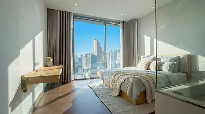 Luxurious bedroom with stunning city view and modern decor in high-rise apartment.