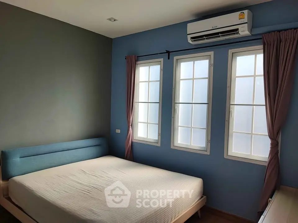Modern bedroom with large windows and air conditioning in a stylish apartment.