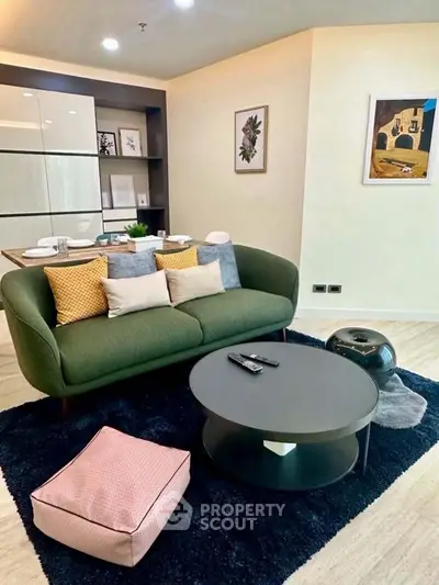 Stylish modern living room with green sofa, chic decor, and cozy ambiance.