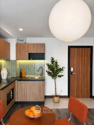 Modern kitchen with stylish wood cabinets and cozy dining area in contemporary apartment.