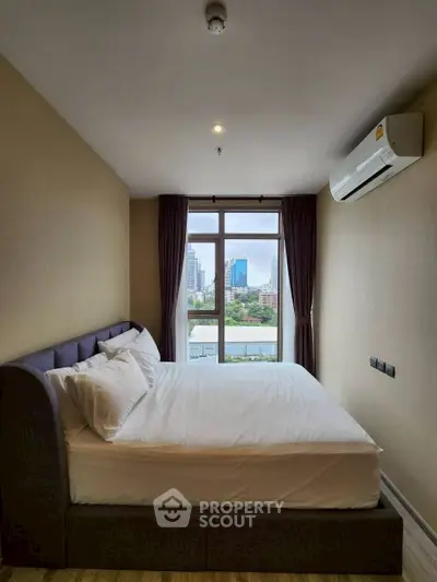 Cozy bedroom with city view and modern air conditioning unit.