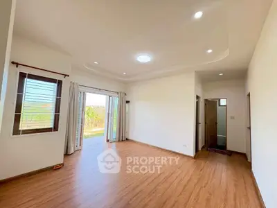 Spacious living room with wooden flooring and garden view