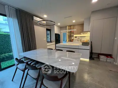 Modern kitchen with marble dining table and garden view