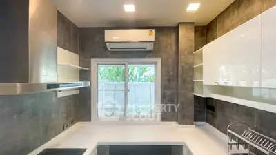 Modern kitchen with sleek design, featuring built-in appliances and large window for natural light.