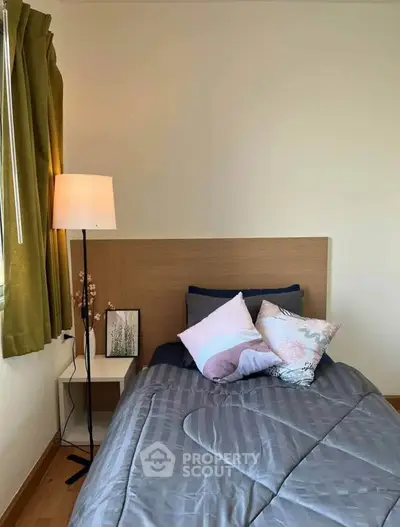 Cozy bedroom with stylish decor and natural light, perfect for relaxation.