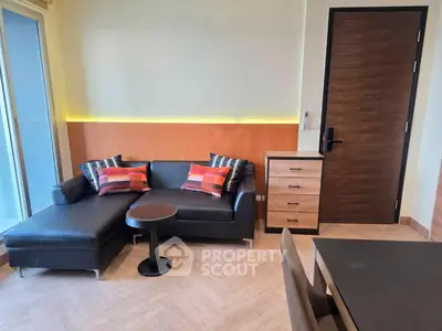 Modern living room with stylish black sofa and chic decor in a contemporary apartment.