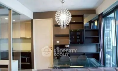 Modern living room with stylish chandelier and glass dining table