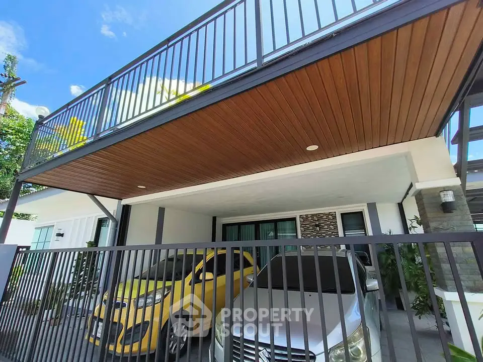 Modern home exterior with covered parking and sleek balcony design.