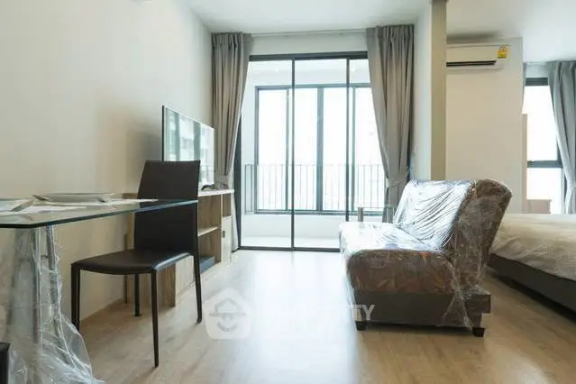 Modern living room with large windows and balcony access in a stylish apartment.