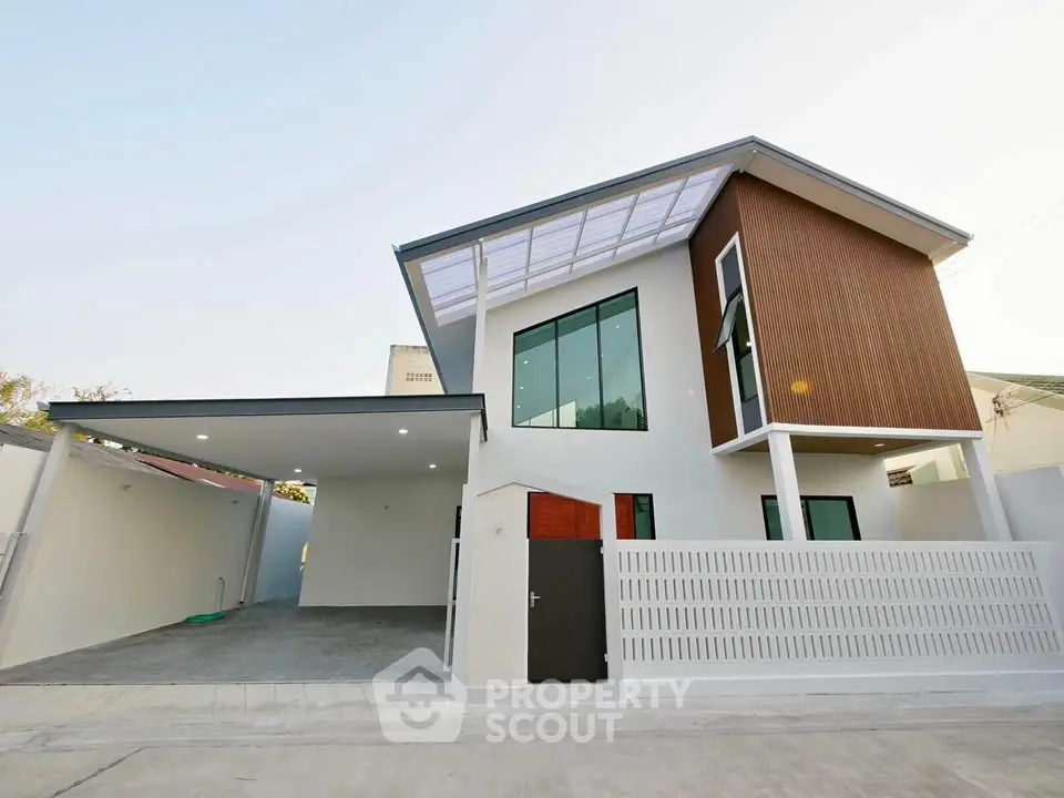 Modern two-story house with sleek design and spacious driveway in a serene neighborhood.