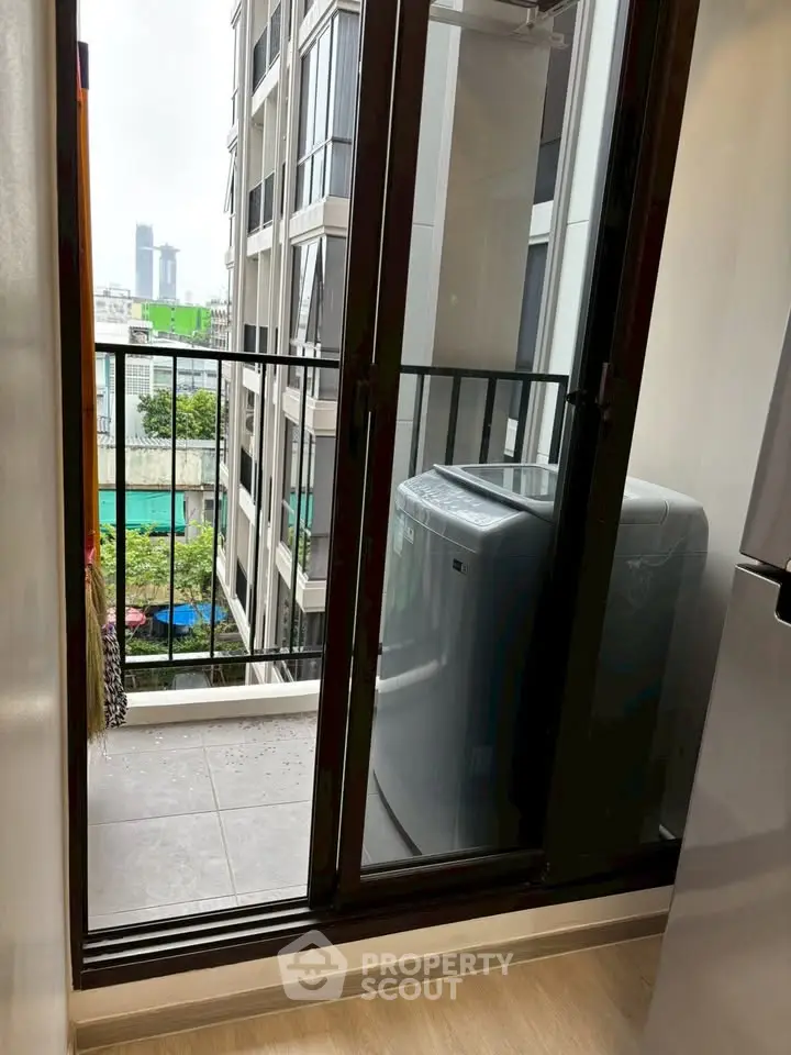 Modern apartment balcony with washing machine and city view