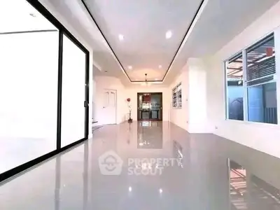 Spacious modern living room with glossy floors and ample natural light