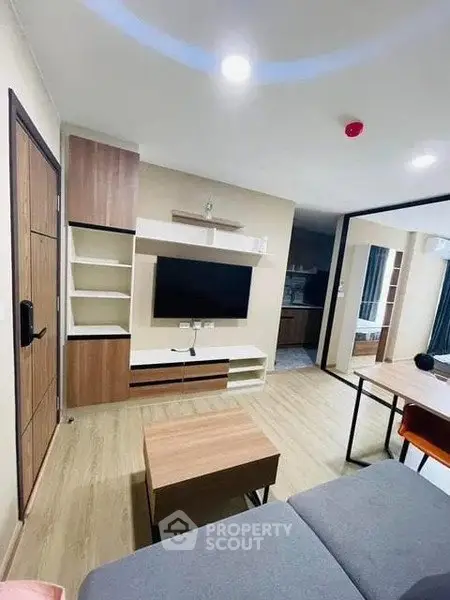 Modern living room with sleek TV unit and cozy seating area in stylish apartment.