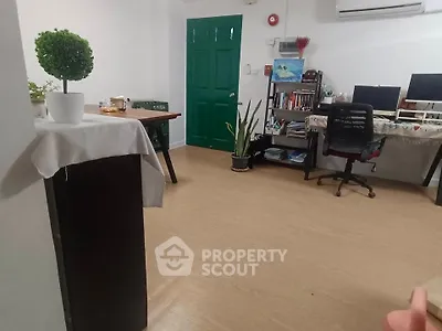 Spacious home office with modern desk and green door, perfect for productivity.