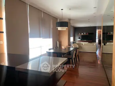 Spacious modern living room with elegant dining area and natural light.