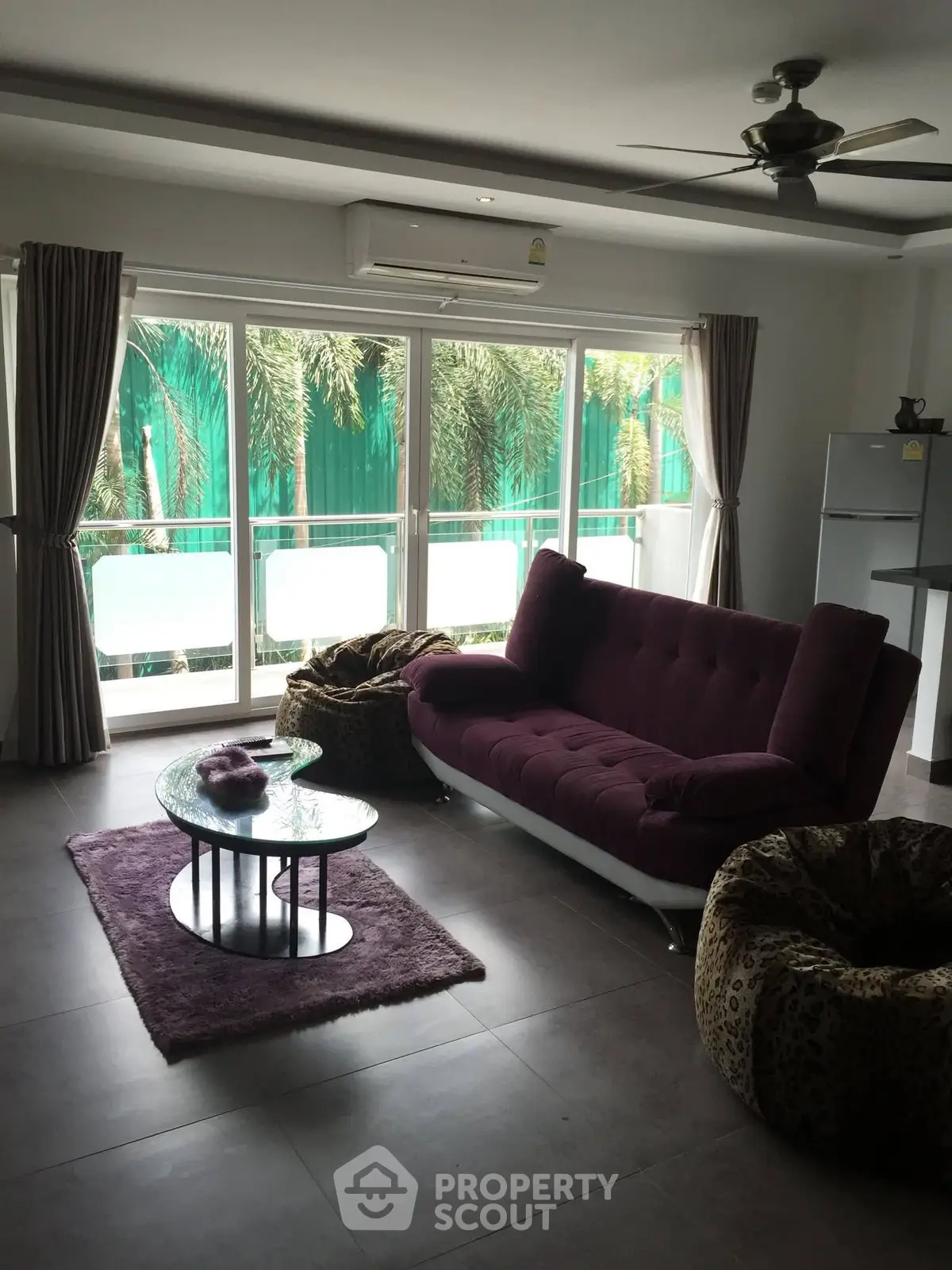 Spacious living room with modern furniture and large windows overlooking greenery.