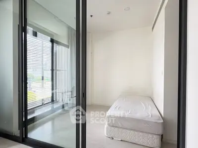 Modern minimalist bedroom with glass sliding doors and balcony view