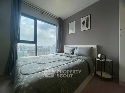 Modern bedroom with large window offering stunning city views and stylish decor.
