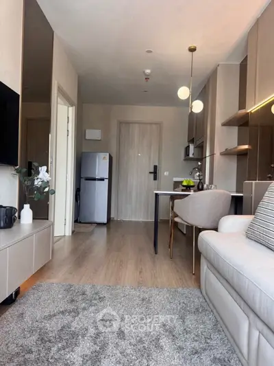 Modern living room with open kitchen, stylish decor, and cozy ambiance in a contemporary apartment.