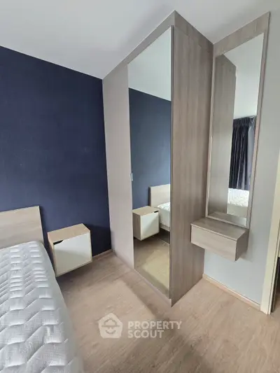 Modern bedroom with stylish wooden furniture and mirrored wardrobe