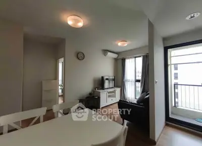Modern living room with dining area and balcony access in a stylish apartment.