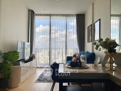 Modern living room with floor-to-ceiling windows and city view, featuring stylish decor and comfortable seating.