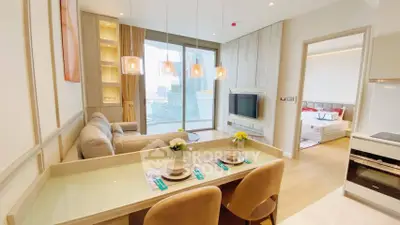 Modern open-plan living room with dining area and city view, featuring elegant decor and natural light.