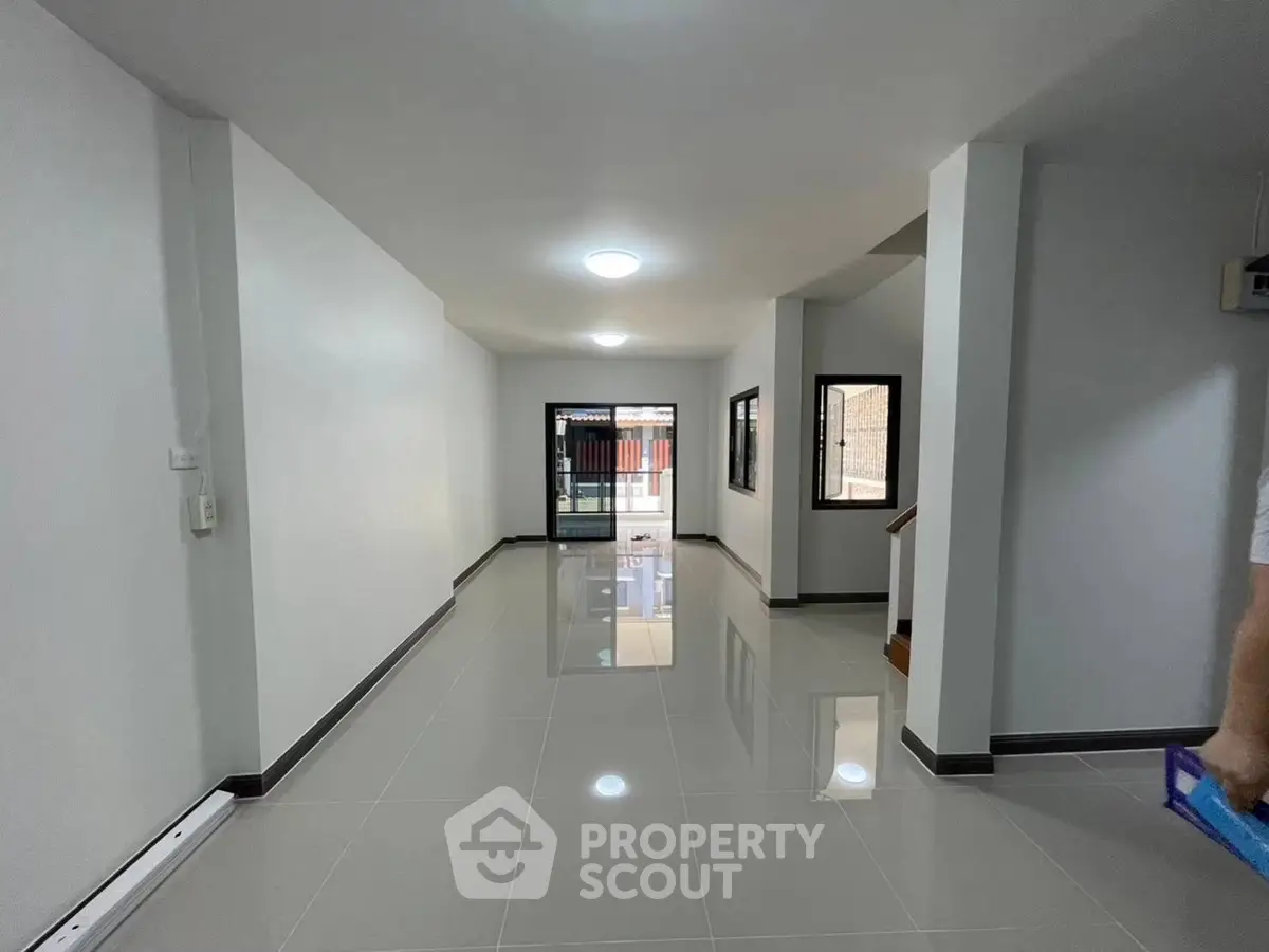 Spacious modern living room with glossy tiled floors and large windows